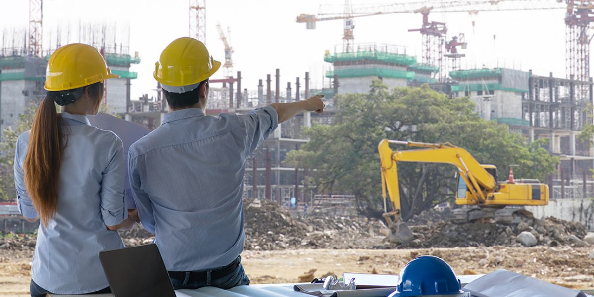 Engineer group and worker meeting, discussion with construction blueprint on site work and point finger to the work site